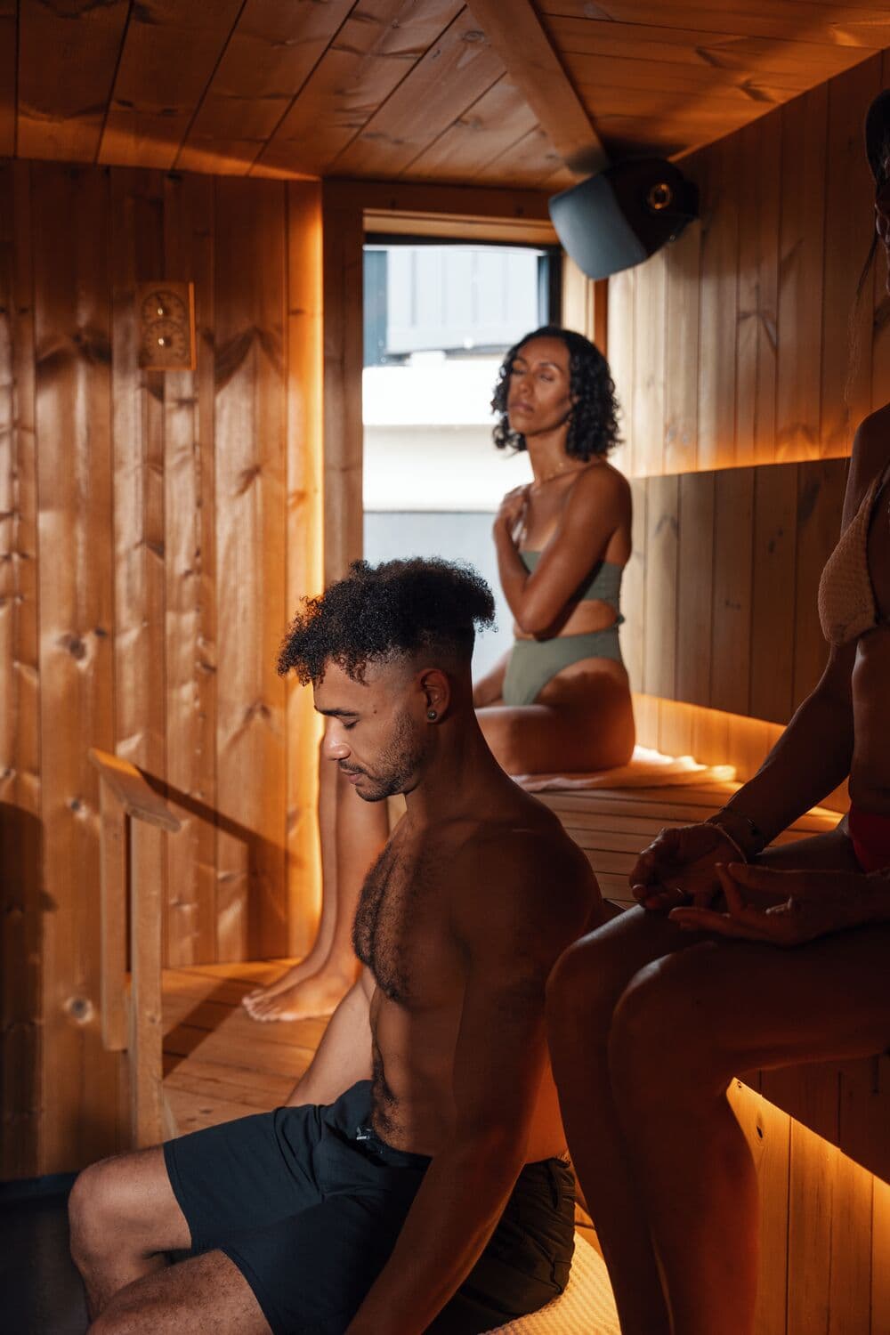 Guests relaxing inside the wood-panelled sauna at Ærth Saunas in Victoria