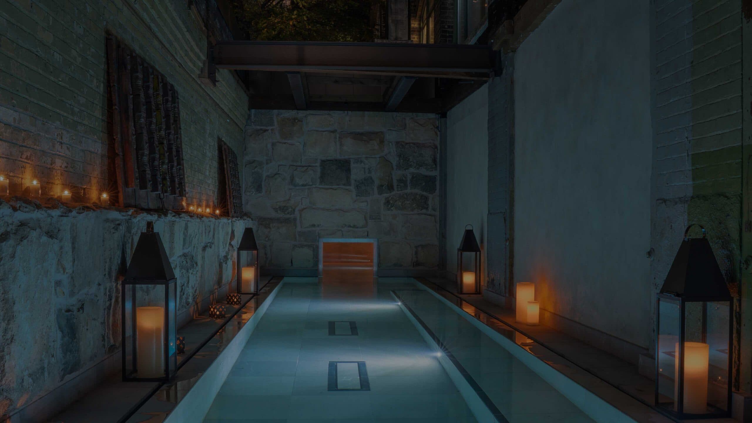 AIRE Ancient Baths Toronto outdoor Palestra bath with candlelit stone walls