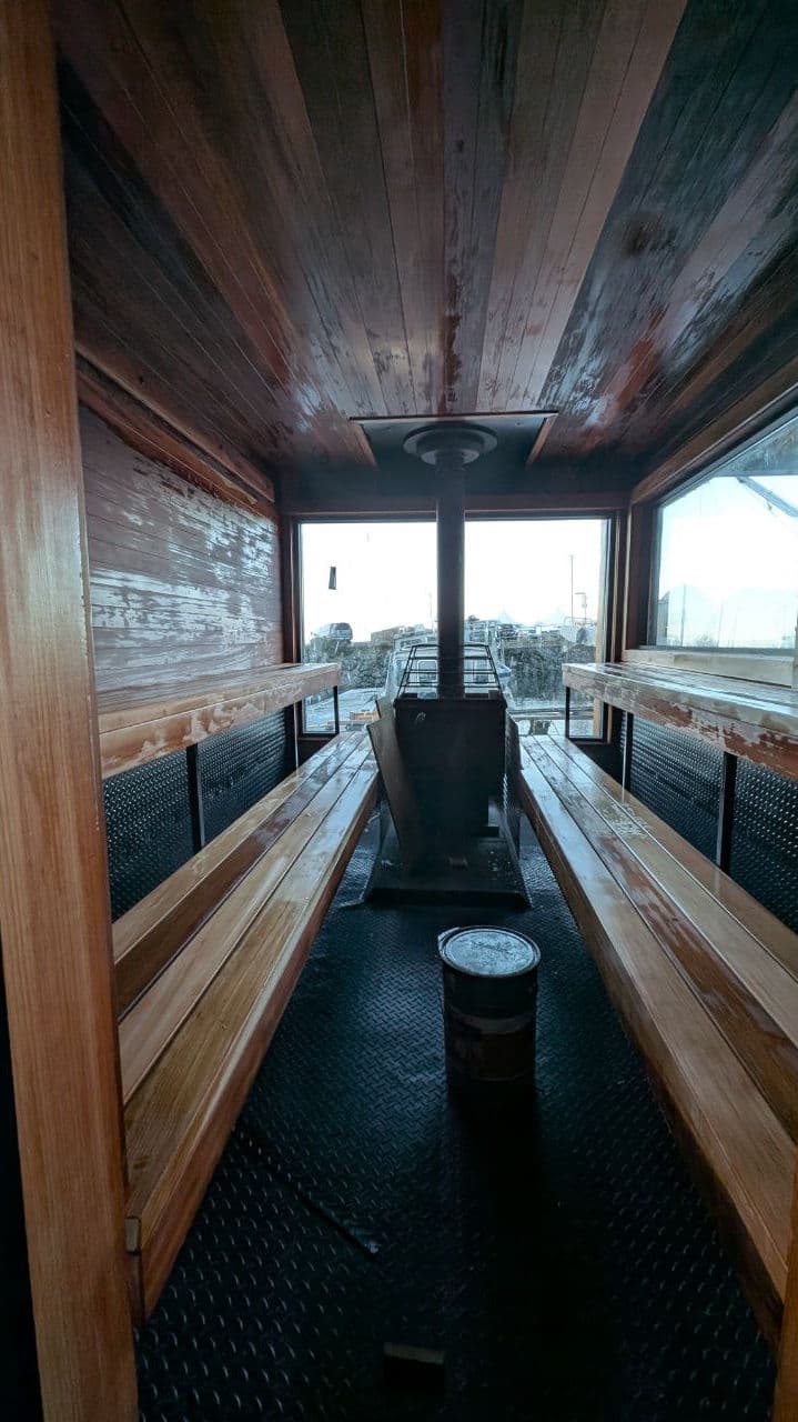 Interior of the floating sauna with wood-fired stove and cedar benches