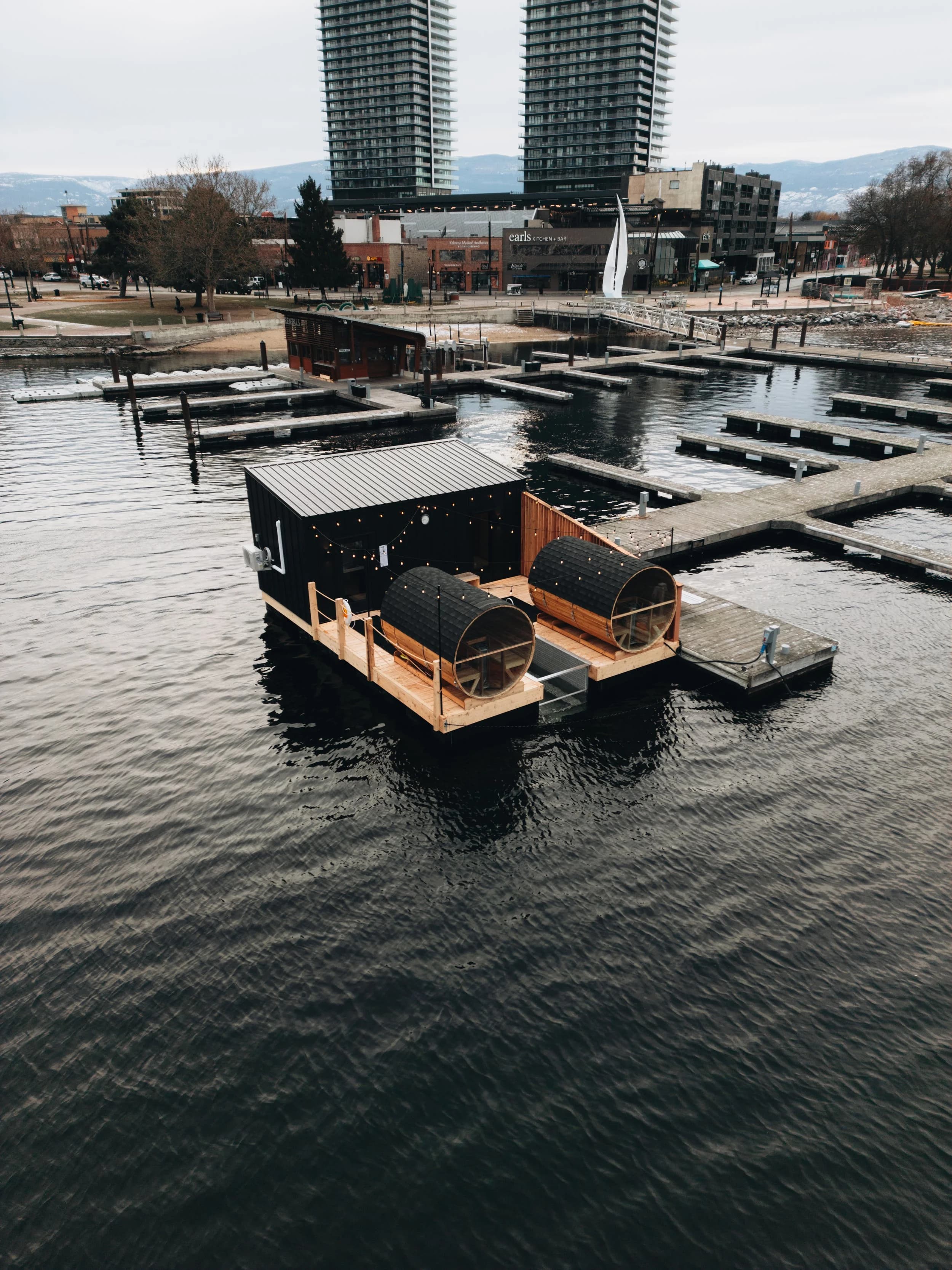 Kuva Wellness floating saunas docked at Kelowna Downtown Marina with city skyline