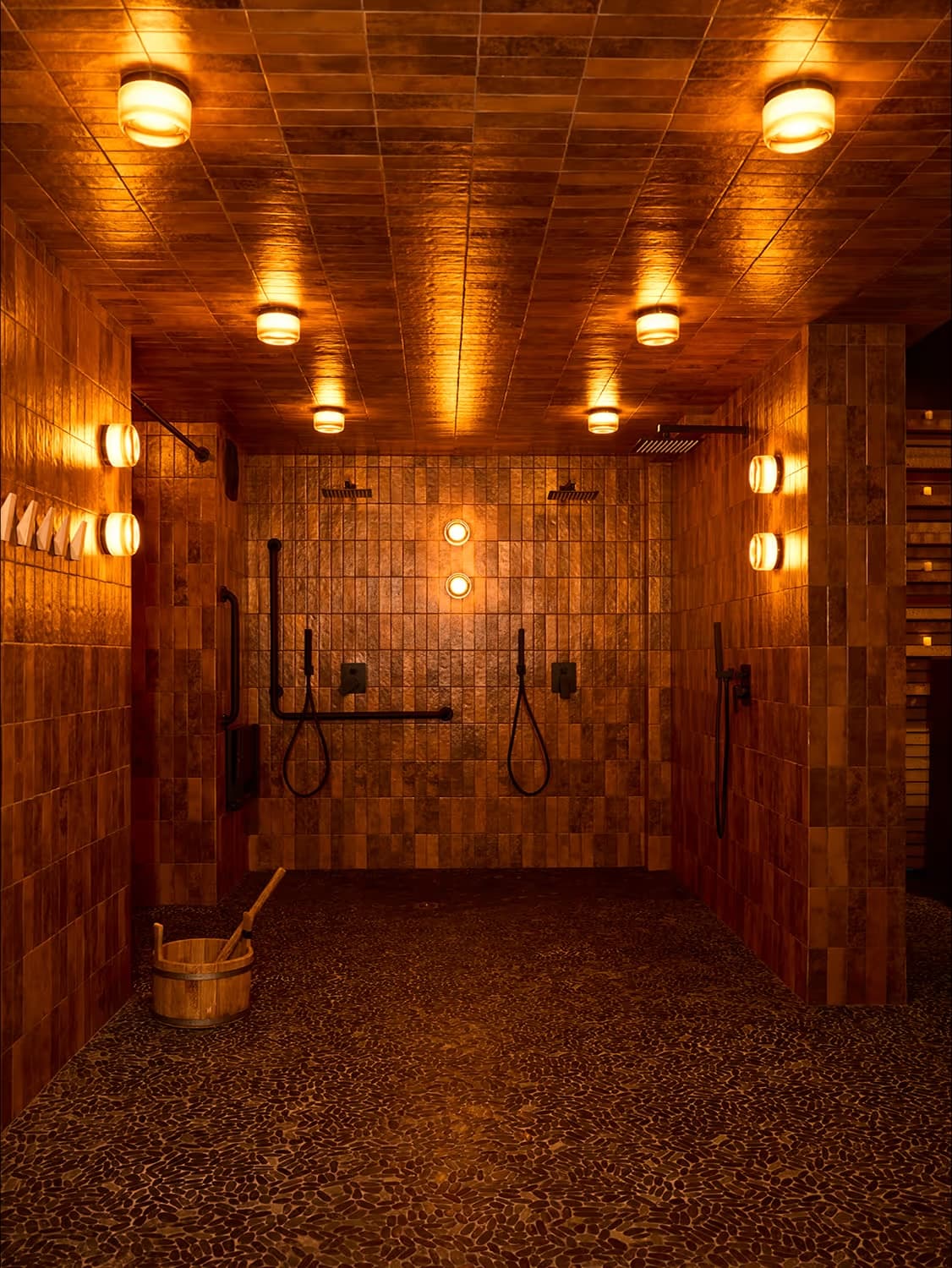 Othership Adelaide interior with warm amber-toned tile walls and rain shower stations