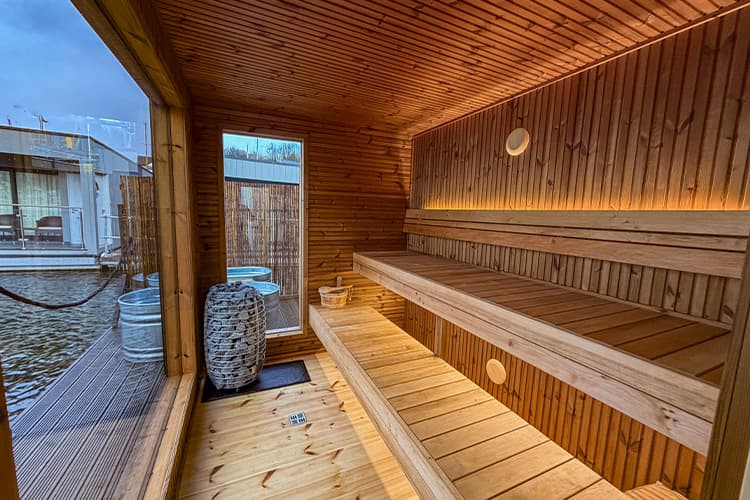 Inside the Sauna Flô floating sauna with Huum heater and marina views through the window