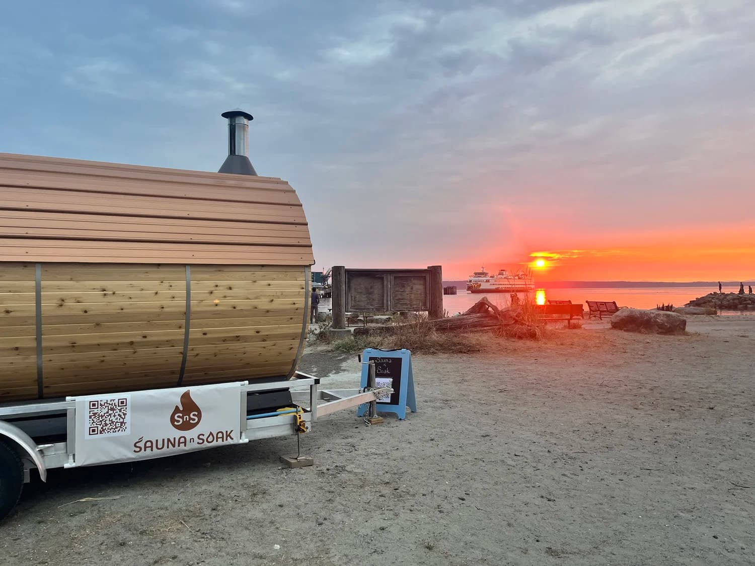 Sauna N Soak barrel sauna on the beach at sunset
