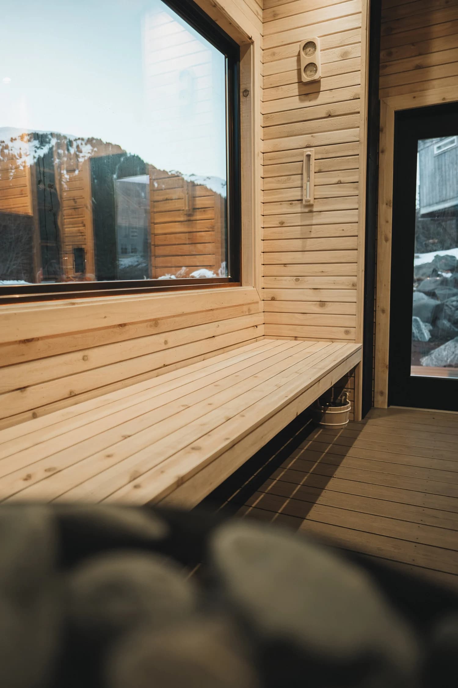 Interior of the Aialik mobile sauna with wooden bucket and sauna accessories on a cedar bench