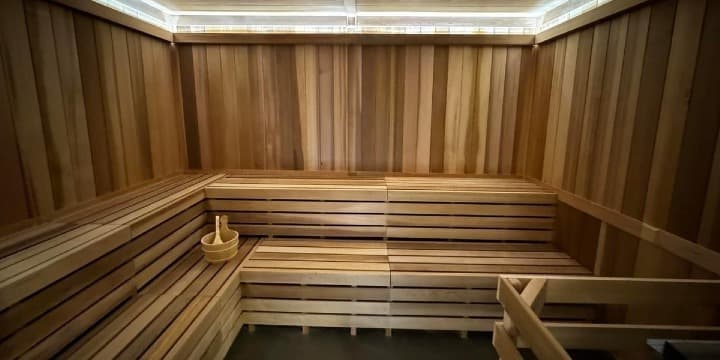 Sisu Sauna cedar interior with tiered benches and wooden bucket