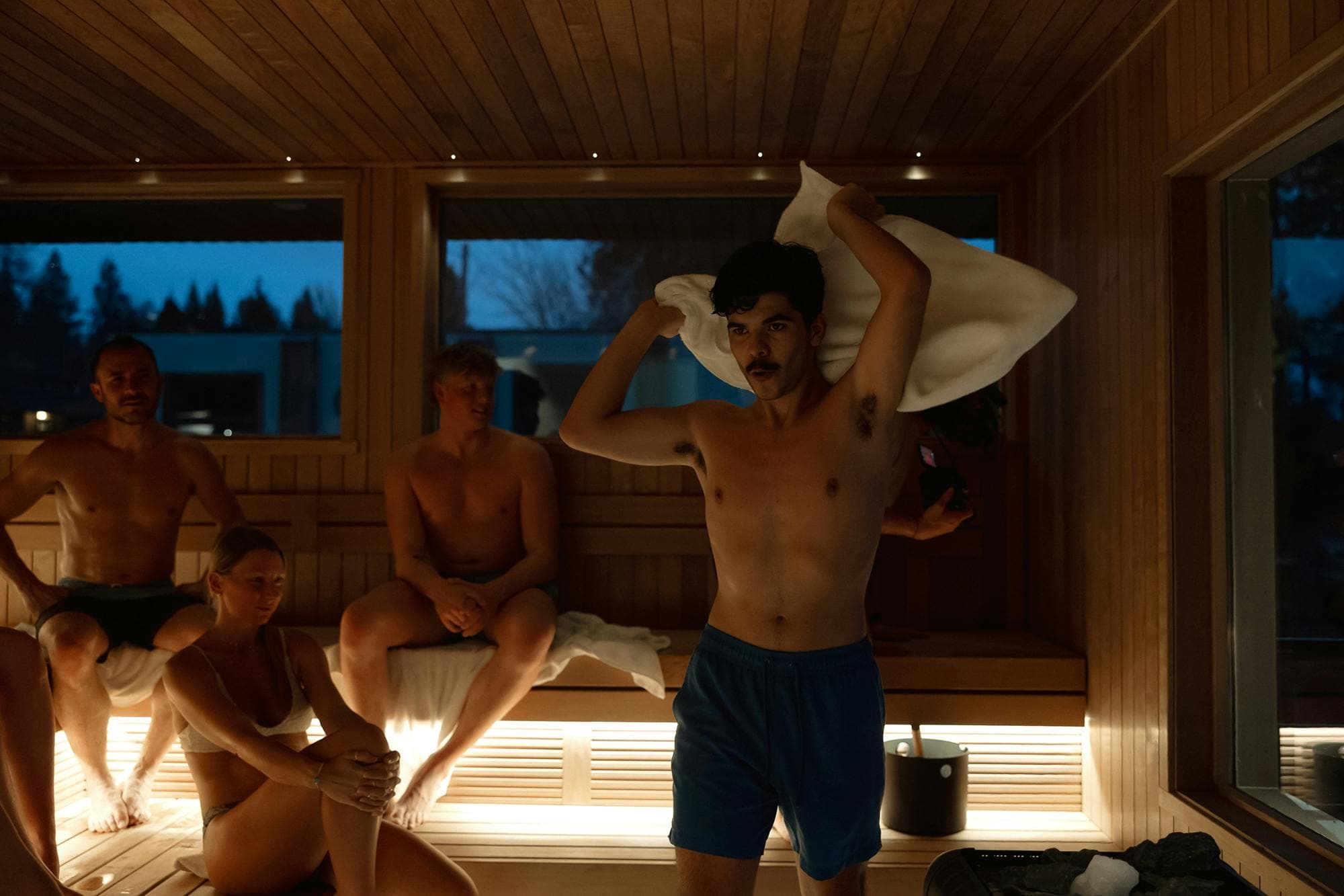 Aufguss session in Symmetry Sauna Studio communal sauna with lake views at dusk