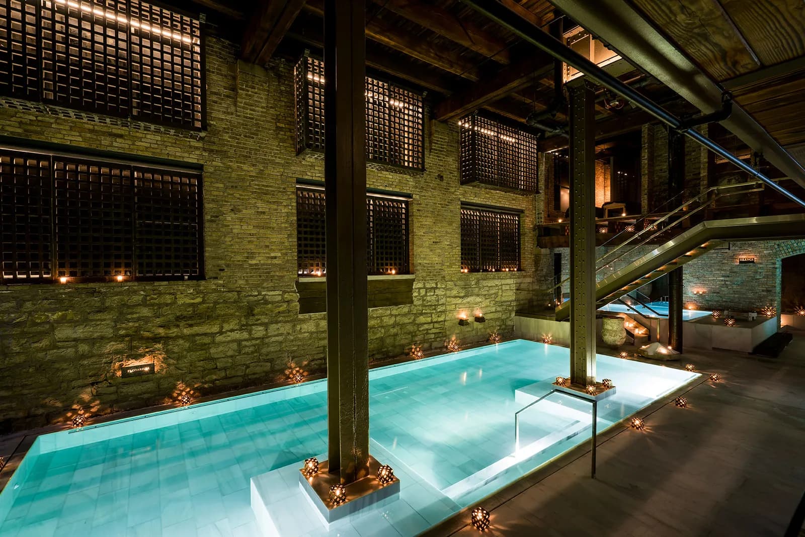 AIRE Ancient Baths Chicago main thermal bath hall with illuminated pools and industrial columns