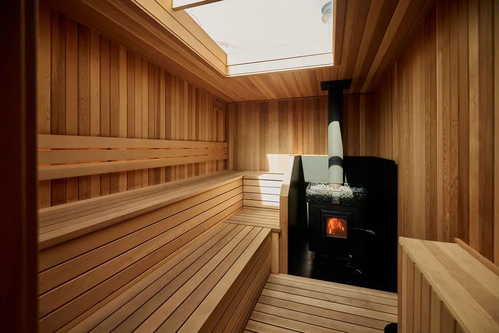Cedar-lined sauna with a wood-fired stove and skylight at All's Well Sauna + Waterspa in Minneapolis