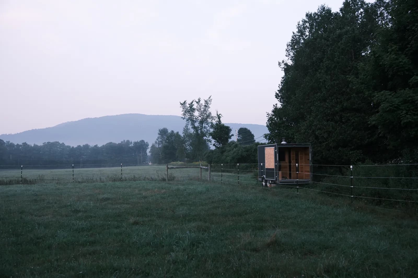 Artisan Portable Saunas trailer in a Vermont field at dusk