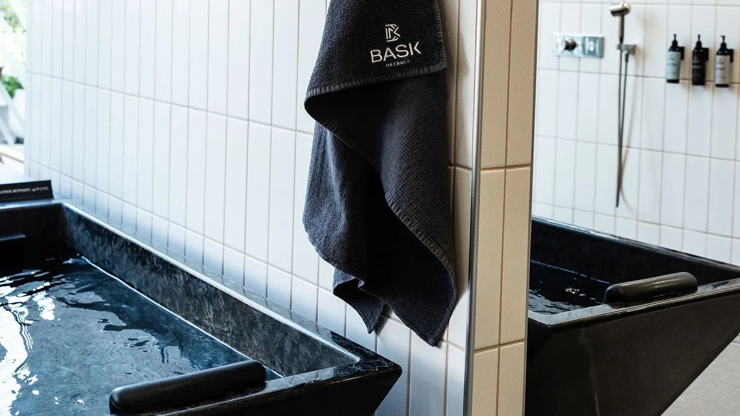 BASK Detroit cold plunge tubs with branded towel and white tile