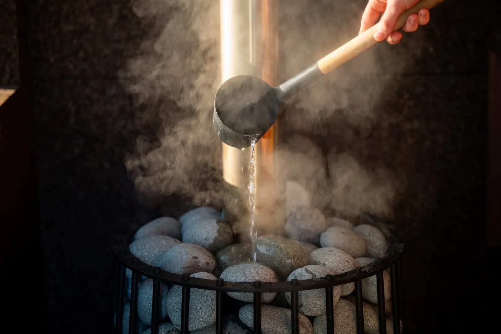 Wood-fired sauna stove with steam at Goodheat Sauna