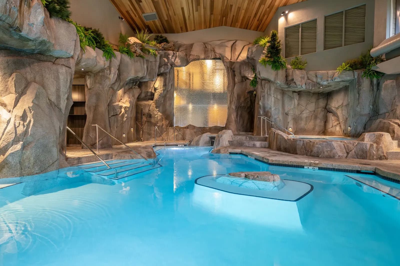 Indoor mineral pool with stone grotto and cascading waterfalls at Grotto Spa