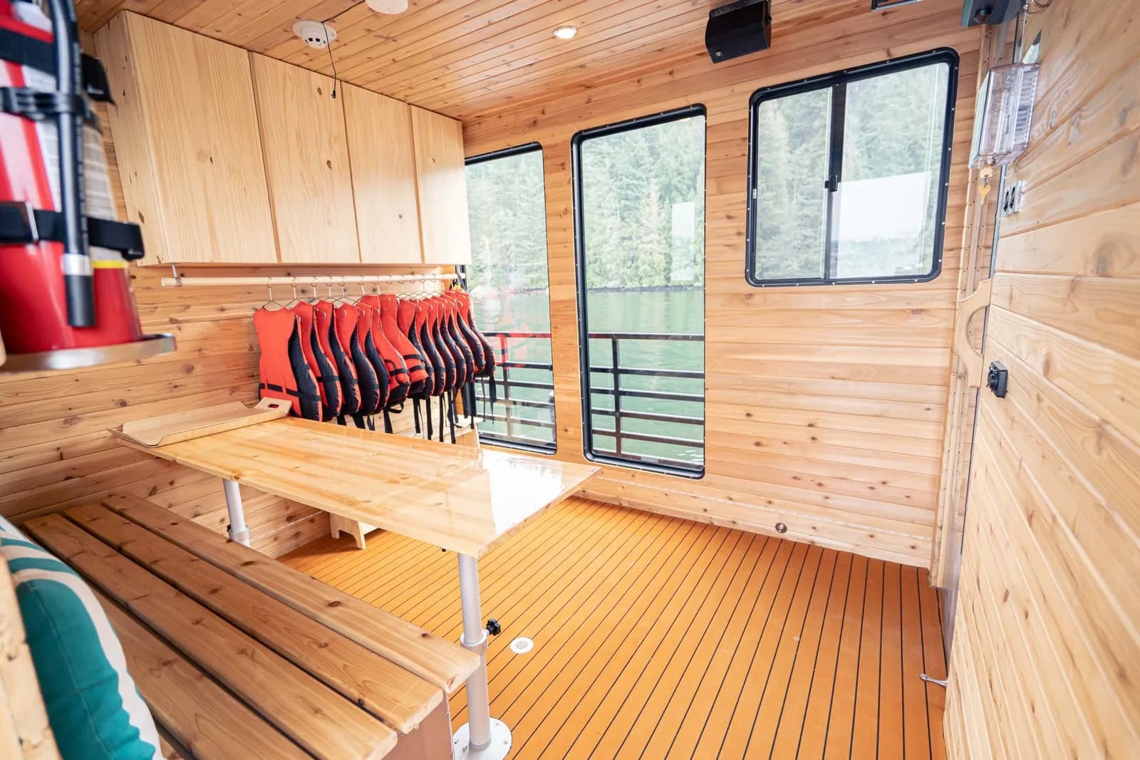 Indoor lounge and changing area on the Hot Voyage sauna boat with cedar benches