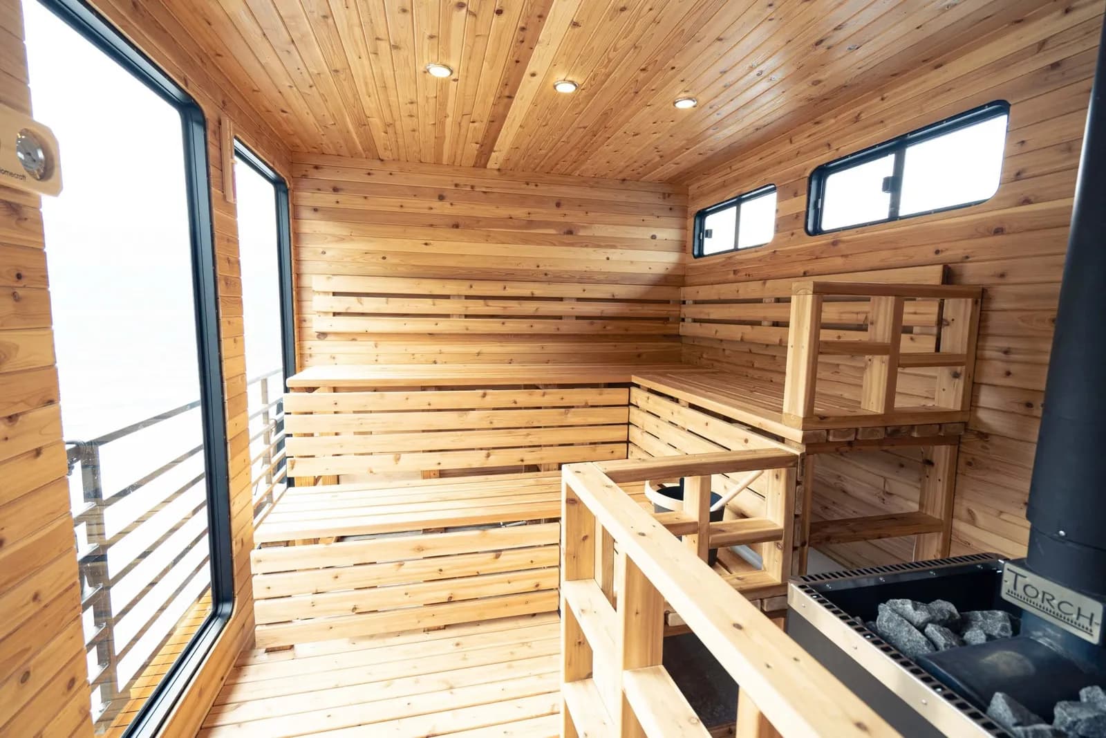 Cedar sauna interior aboard the Hot Voyage boat with panoramic windows over the water