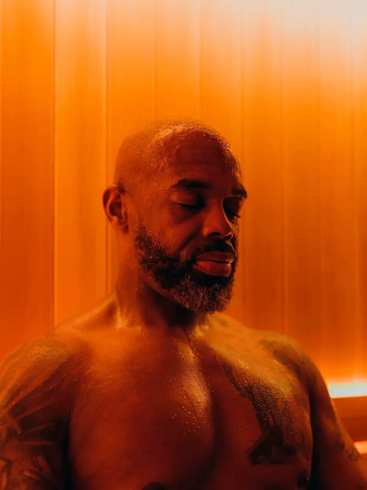 Guest relaxing in the wood-lined sauna at JOY Wellness Club
