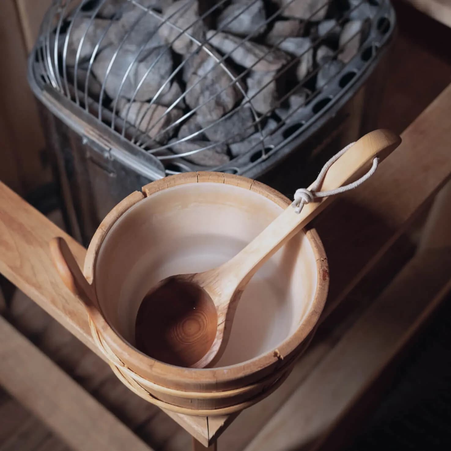 Sauna stove with stones, wooden bucket and ladle at L'Absolu Spa