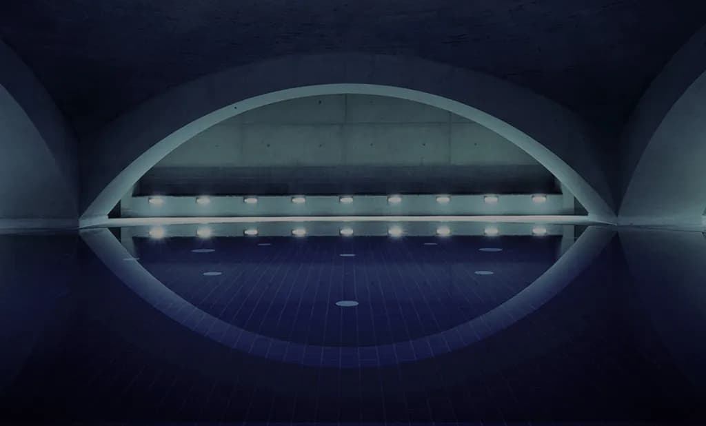 Saltwater floating pool under the iconic concrete dome at Liquidrom Berlin with atmospheric lighting