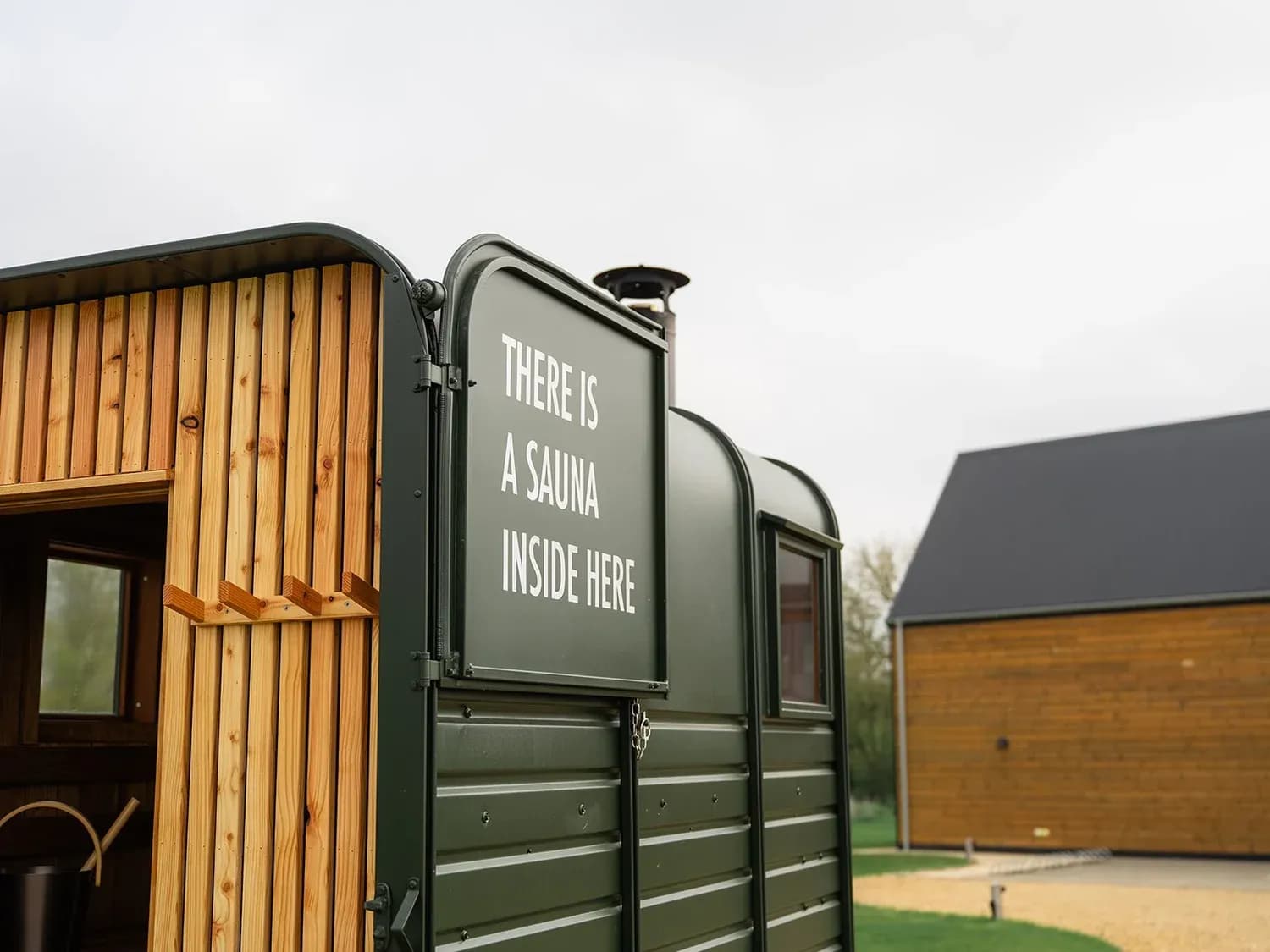 Löyly & Jää horsebox sauna exterior with 'There is a sauna inside here' sign
