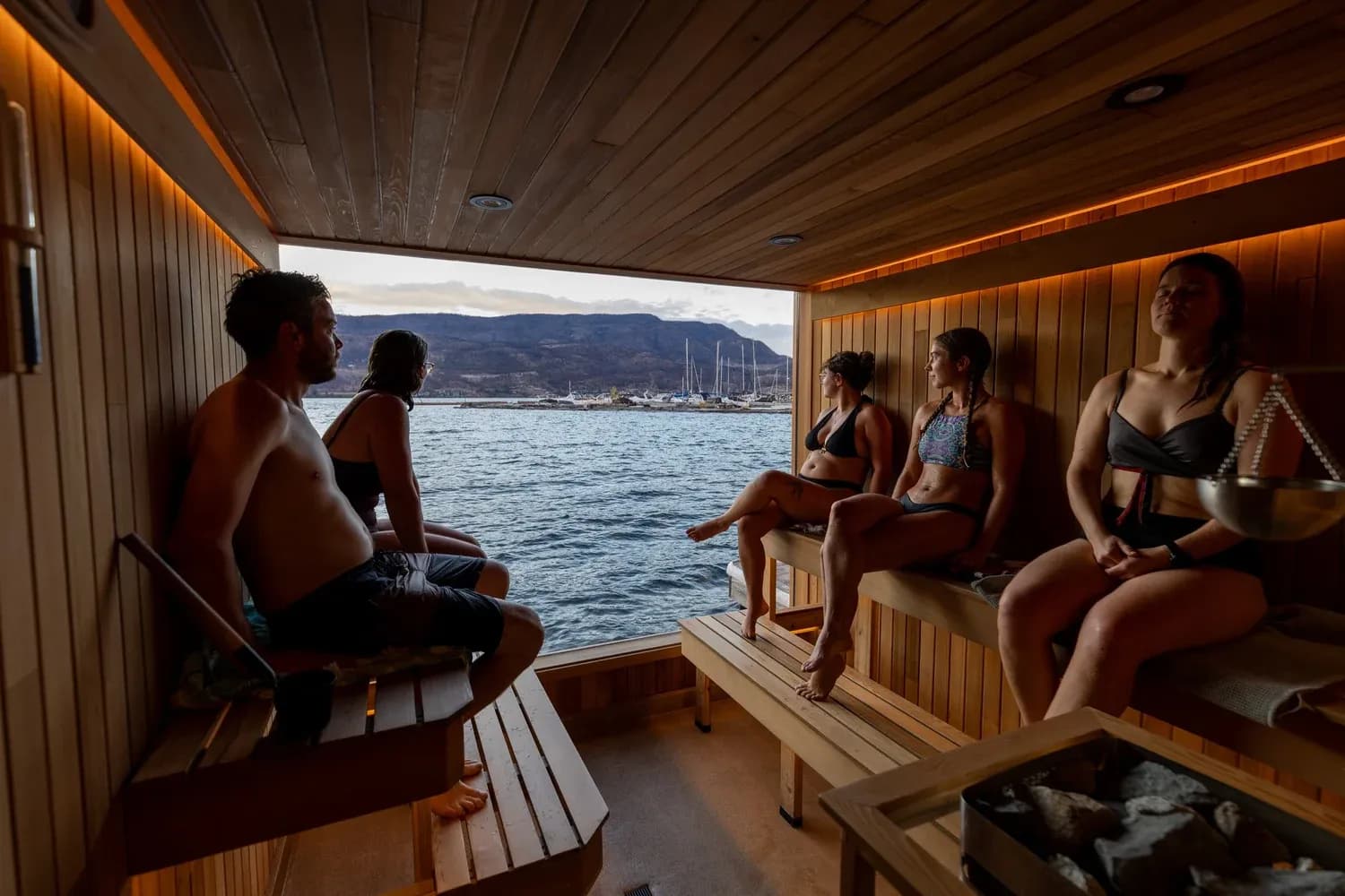 Interior of Löyly Floating Sauna in Kelowna with warm wood paneling and ambient lighting on Lake Okanagan