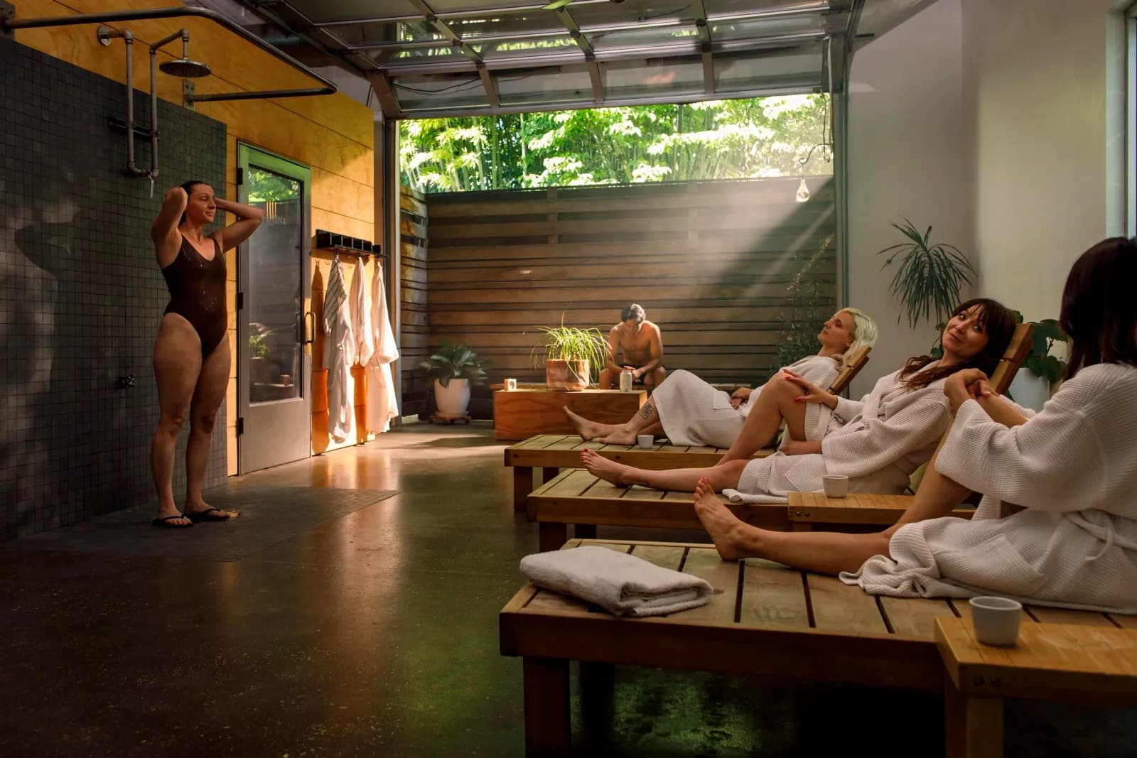 Löyly Southeast courtyard with lounge chairs and outdoor showers