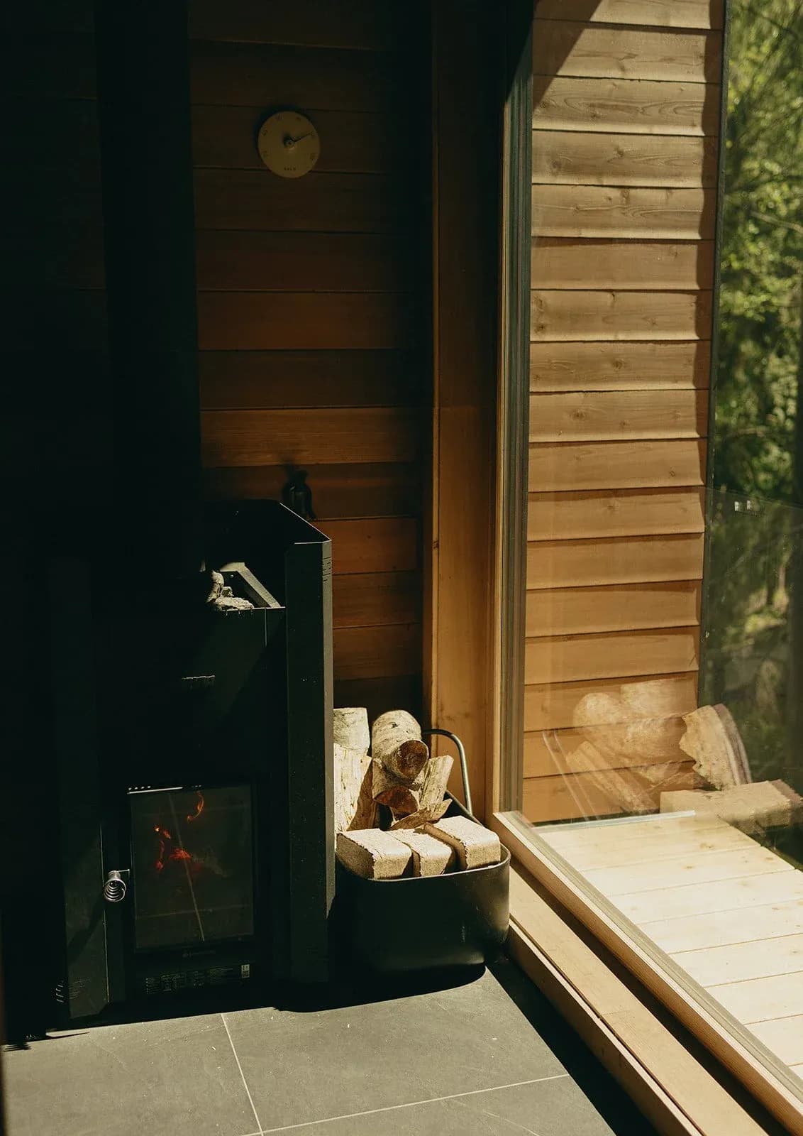 Mist Thermal Sanctuary sauna interior with wood-burning stove and natural light