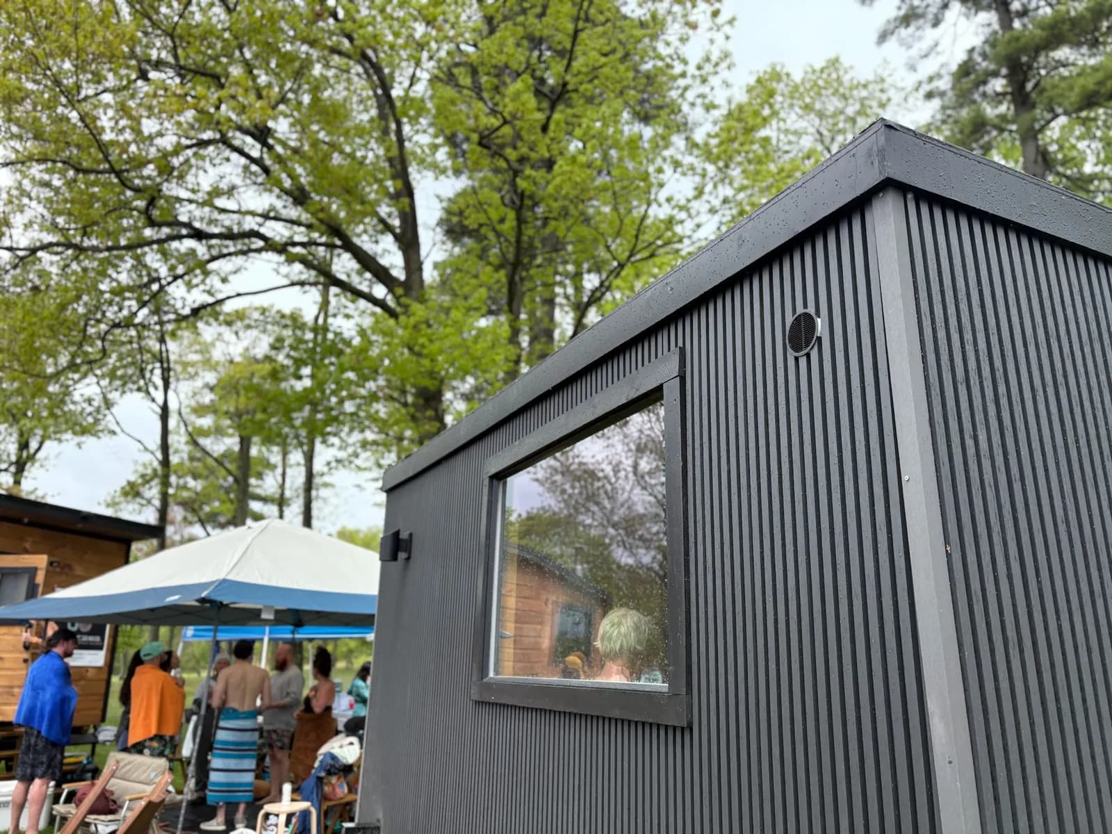 Guests relaxing outside the Northern Kin mobile sauna at a pop-up event