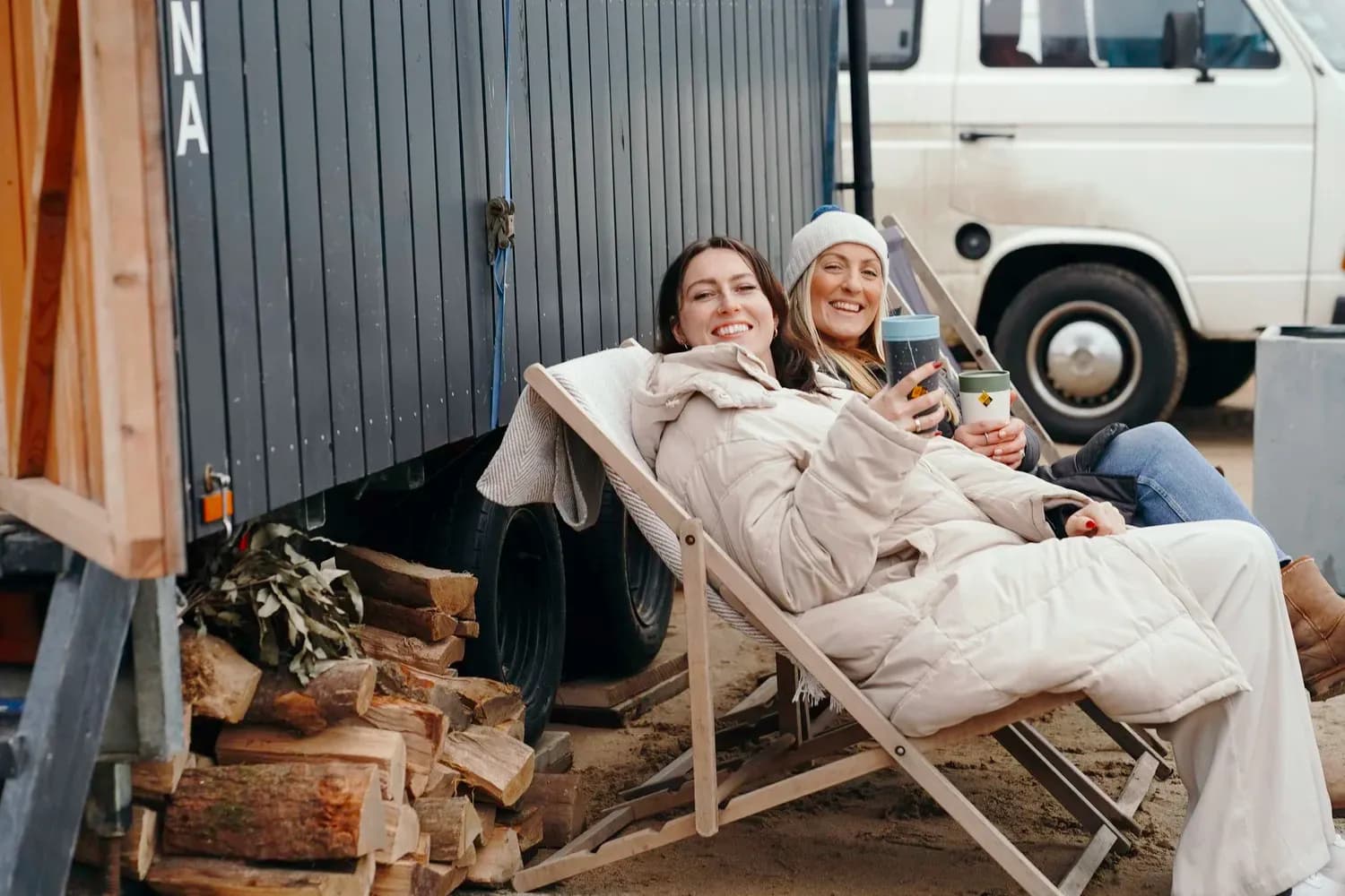Relaxing outside Olla Hiki Sauna with firewood and ocean views in Newquay