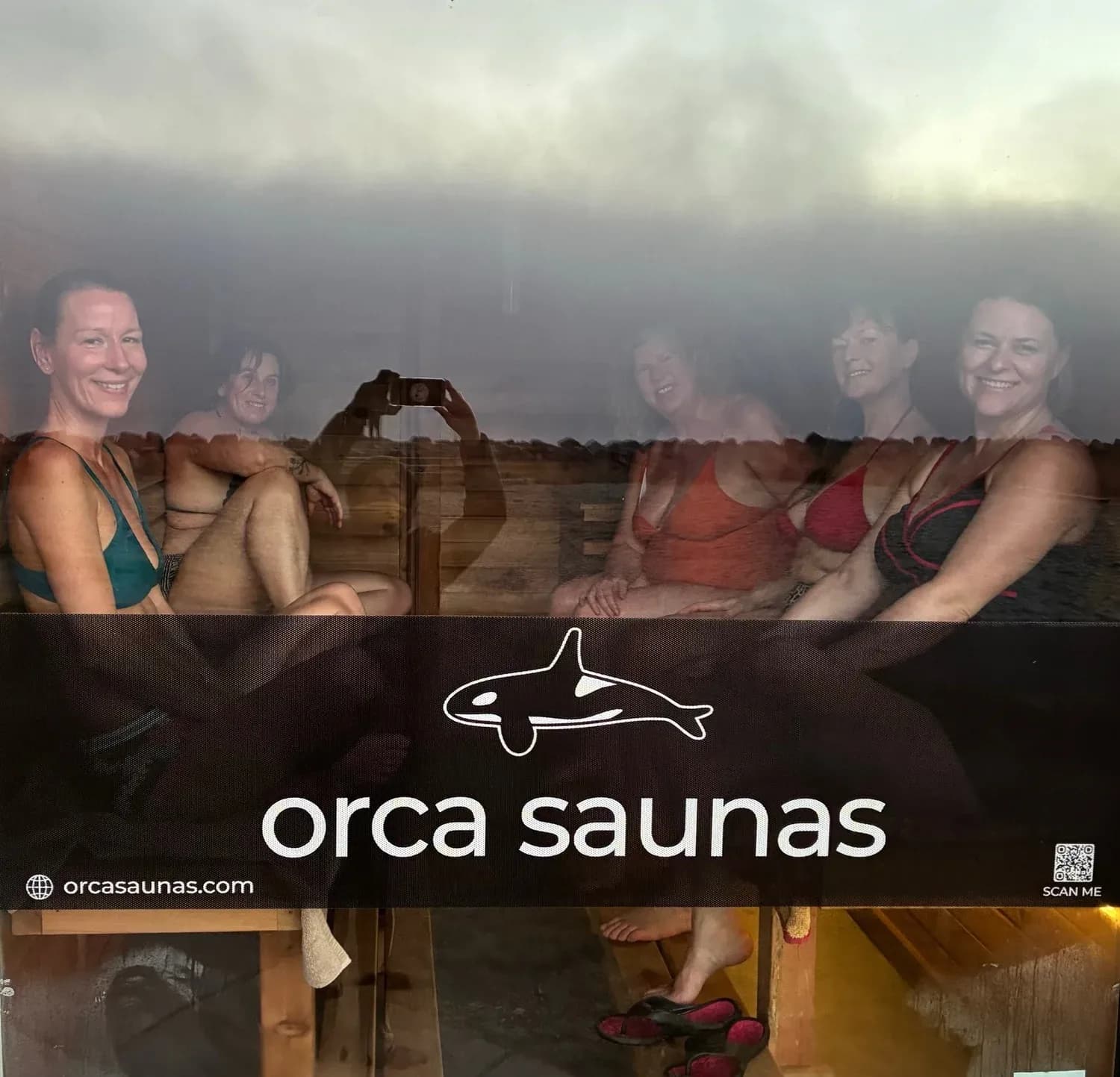 Guests inside the Orca Saunas oceanside sauna