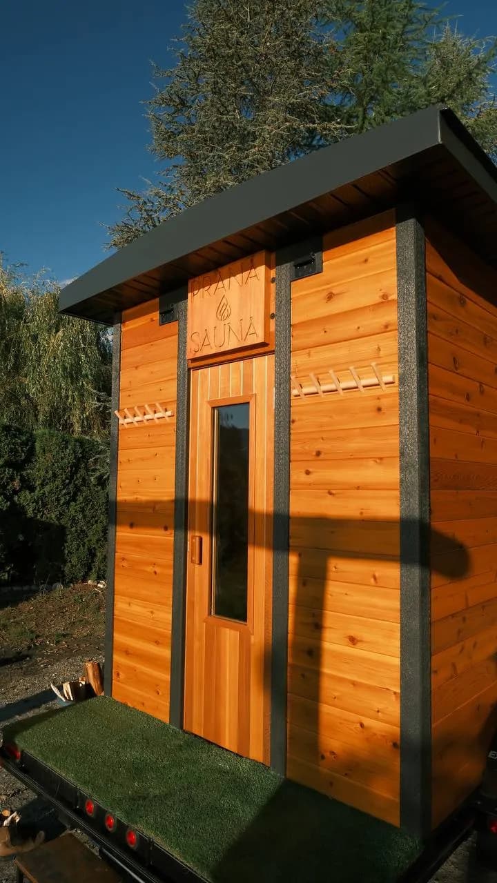 Front door of the Prana Sauna trailer with the carved Prana Sauna sign above