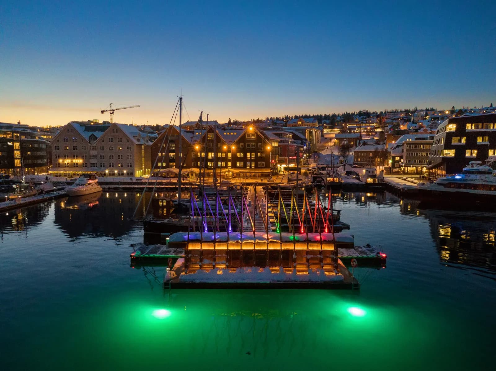 Aerial view of Pust floating saunas in Tromsø harbour at dusk