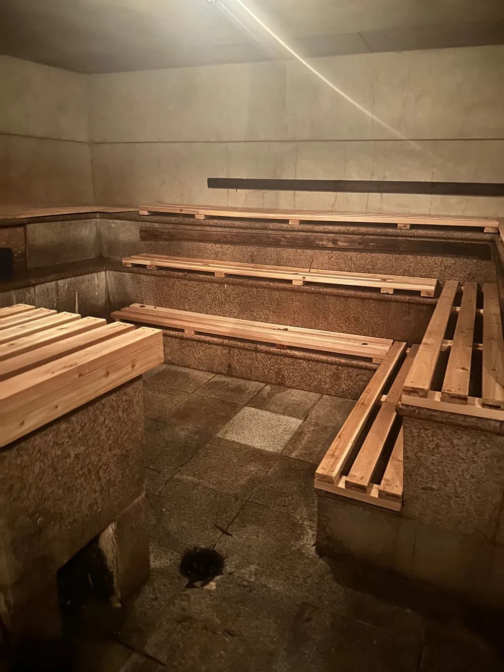 Russian & Turkish Baths radiant heat Russian room with stone walls and wooden benches
