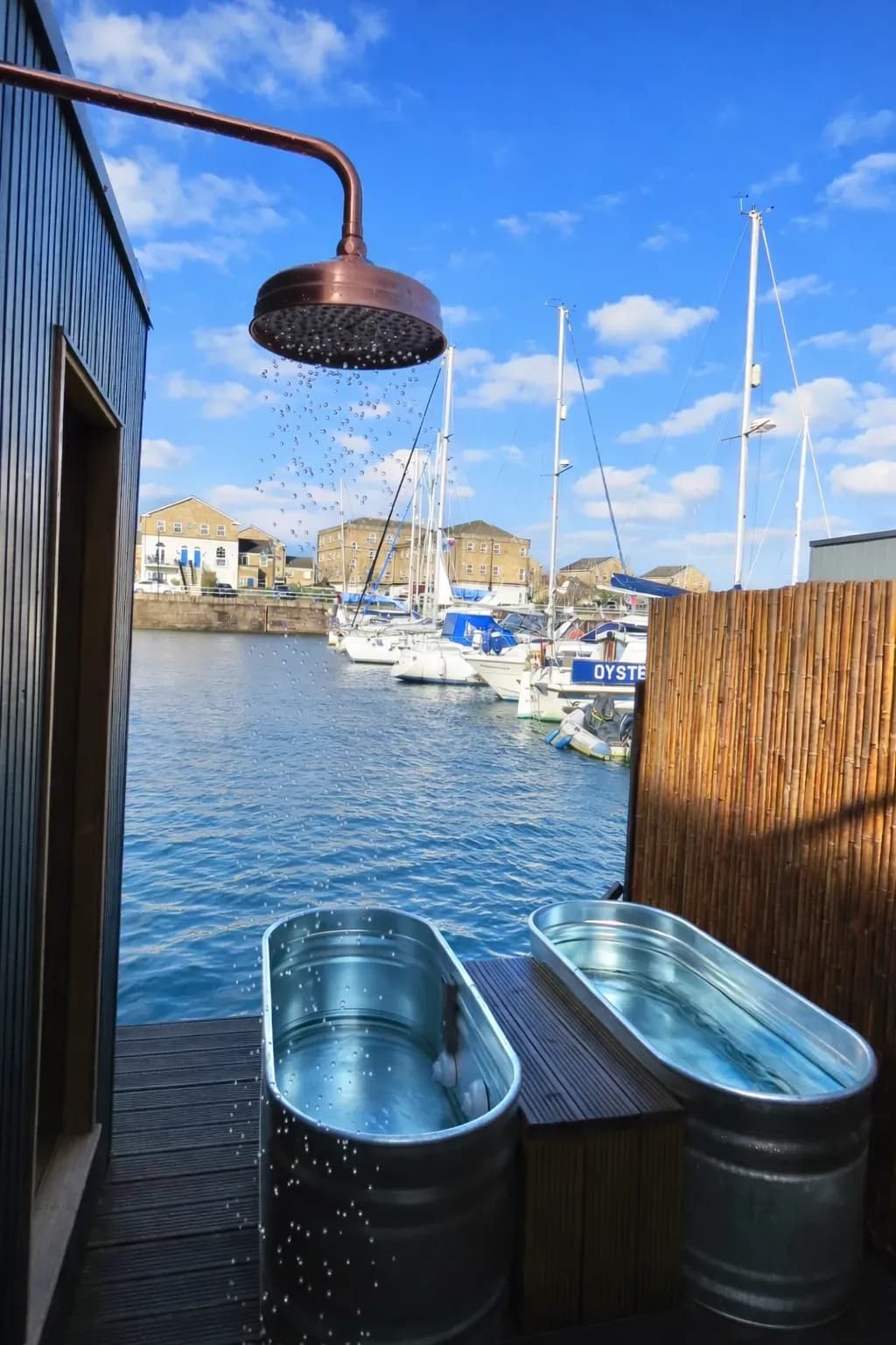 Sauna Flô exterior with outdoor shower overlooking Penarth Marina boats