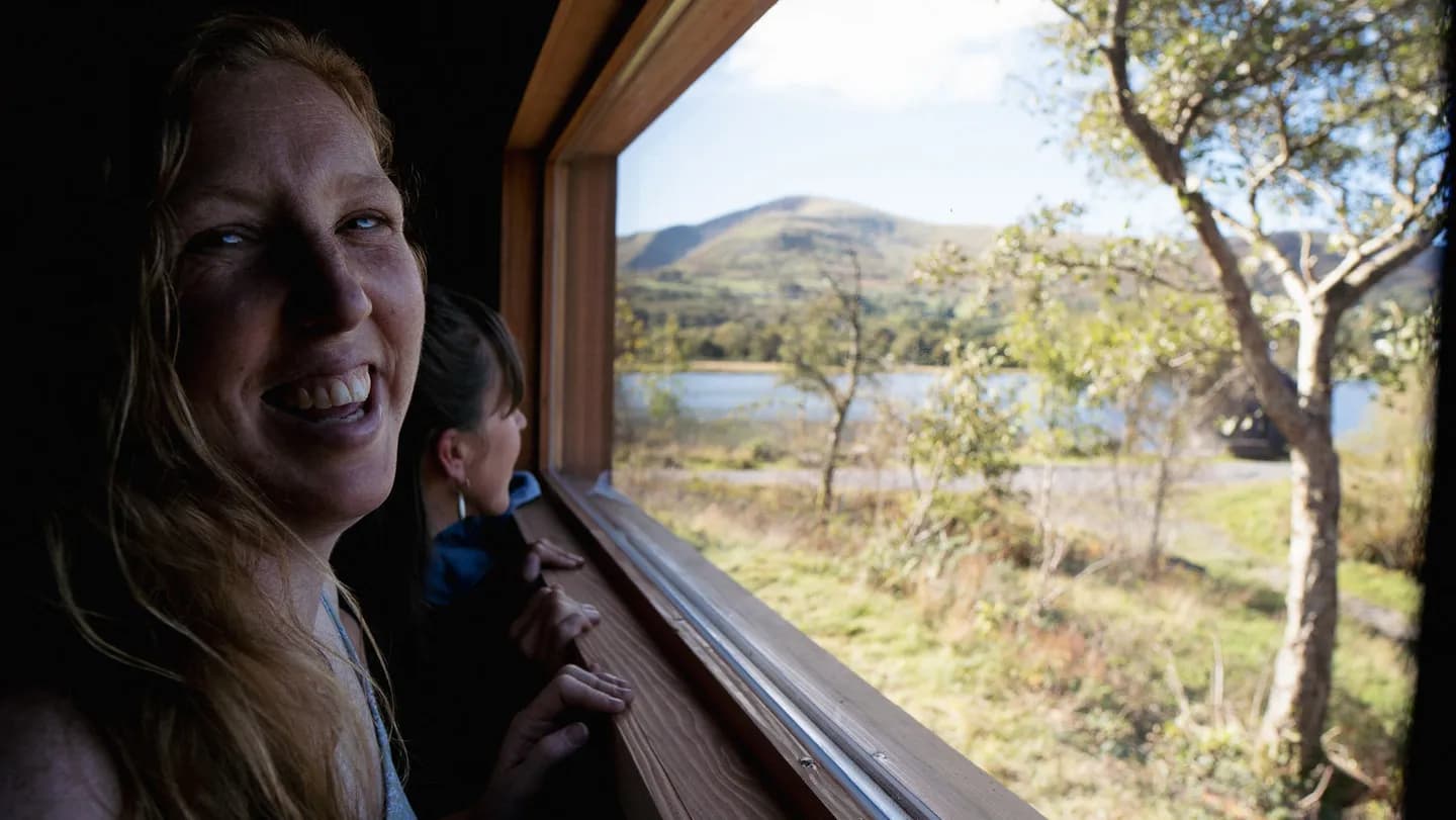 Sawna Bach Llanberis sauna interior with guests looking out towards Llyn Padarn lake