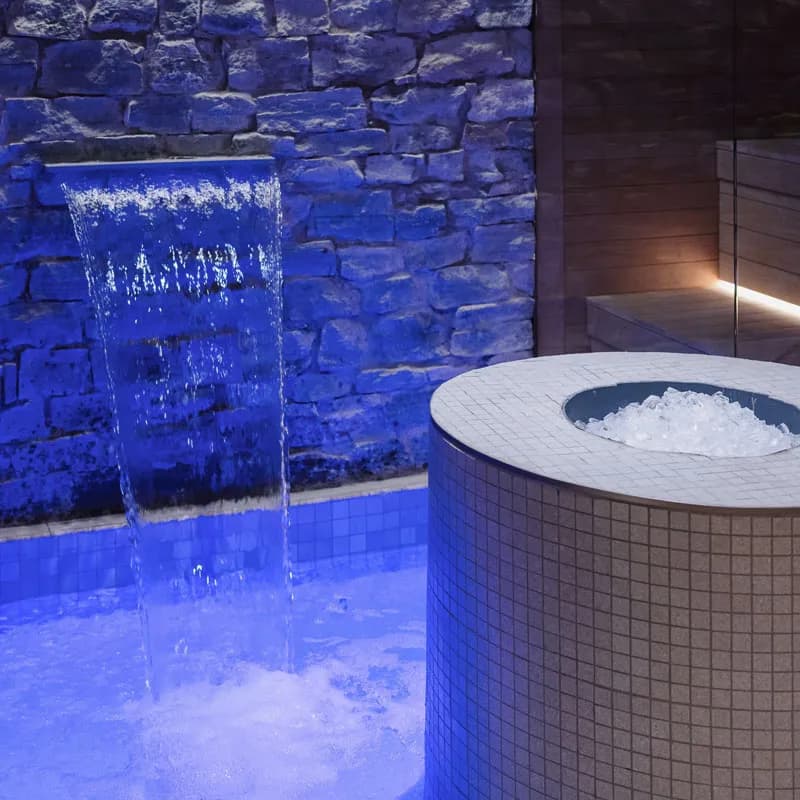 Ice bath and cascading water against a stone wall at Spa Carré St-Louis
