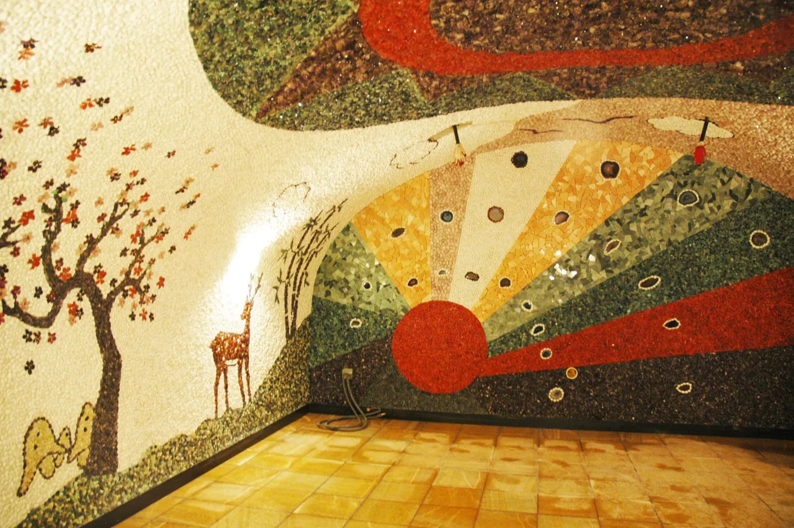 Gemstone poultice room at Spa World with a colorful mineral-mosaic mural of a tree, deer and rising sun