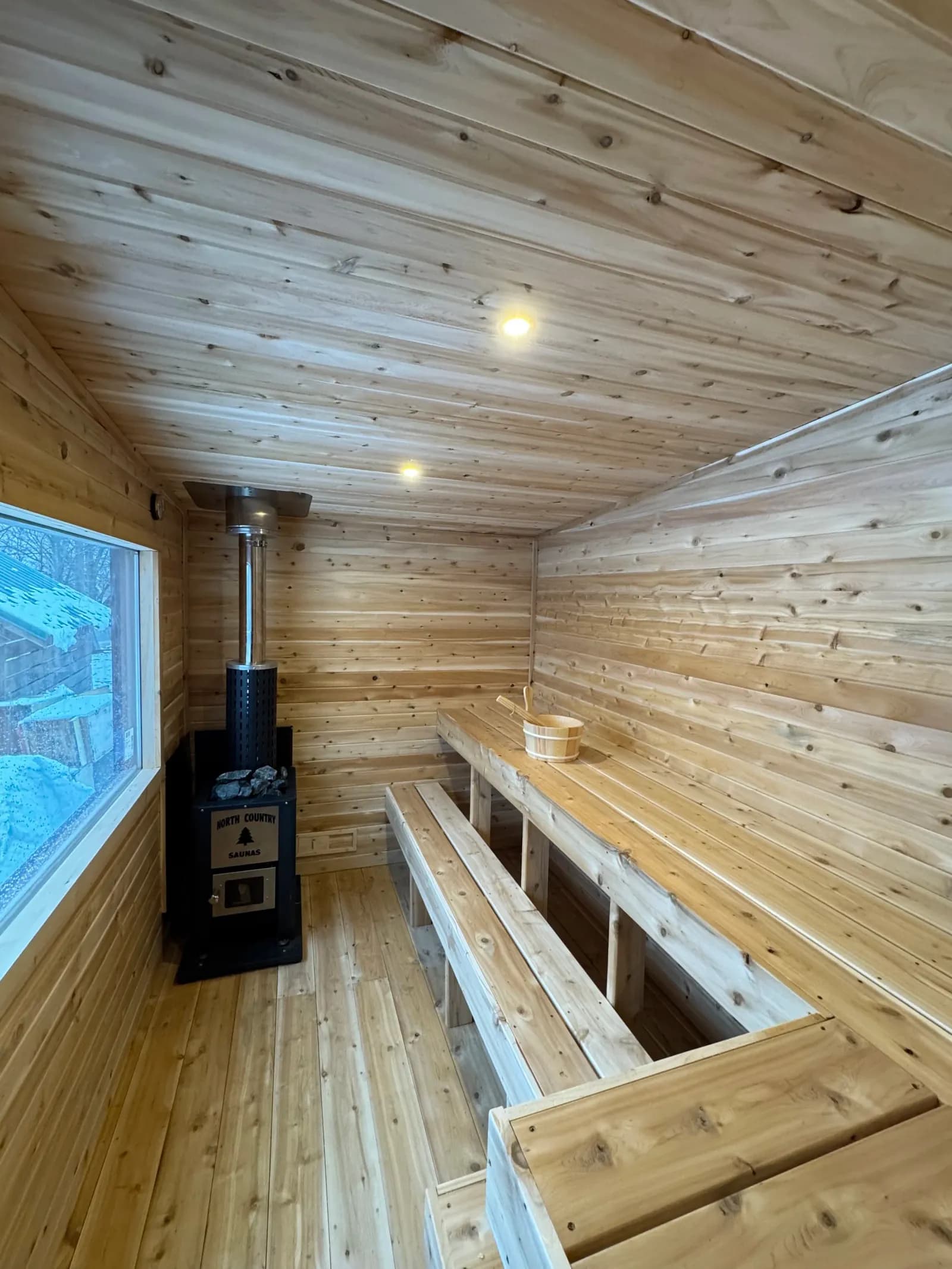 Cedar interior and wood stove of the Stella Blue mobile sauna