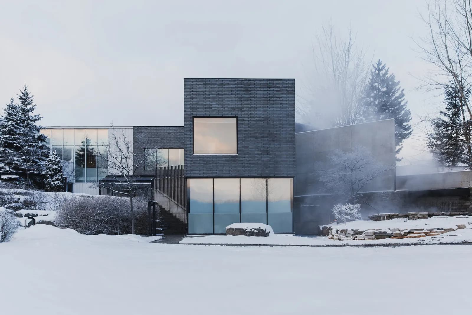 Strøm Spa Nordique Île-des-Sœurs buildings in winter with steam rising from the baths
