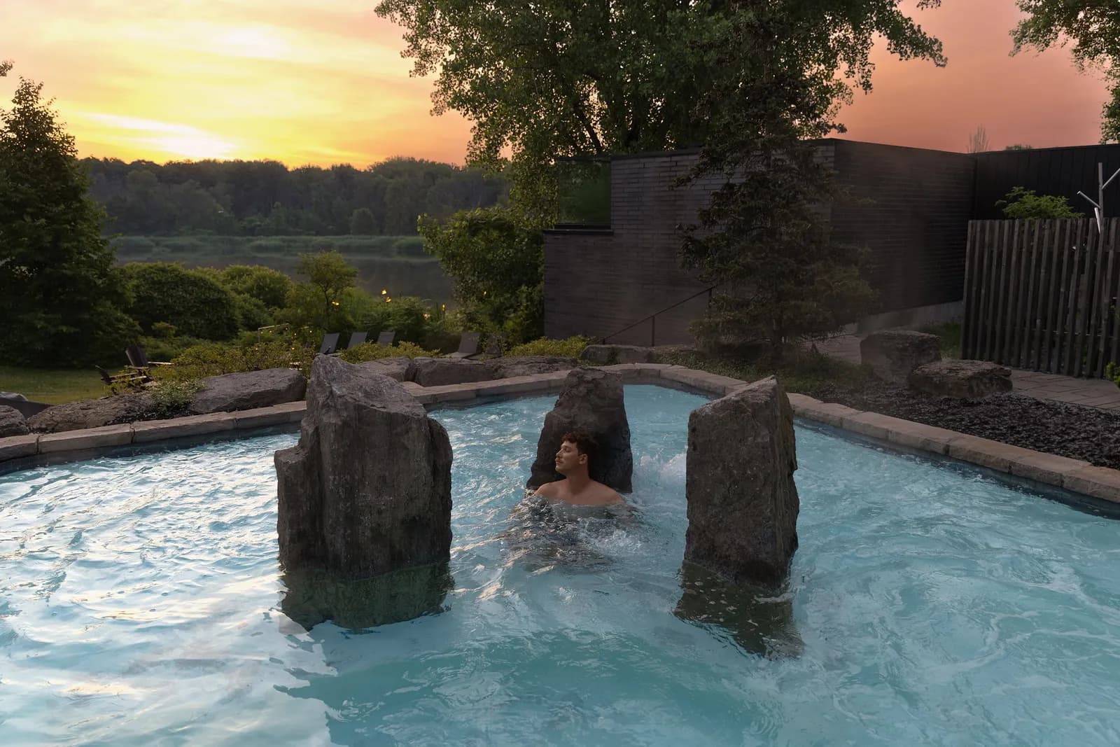 Outdoor hot bath with standing stones at sunset, Strøm Spa Nordique Île-des-Sœurs