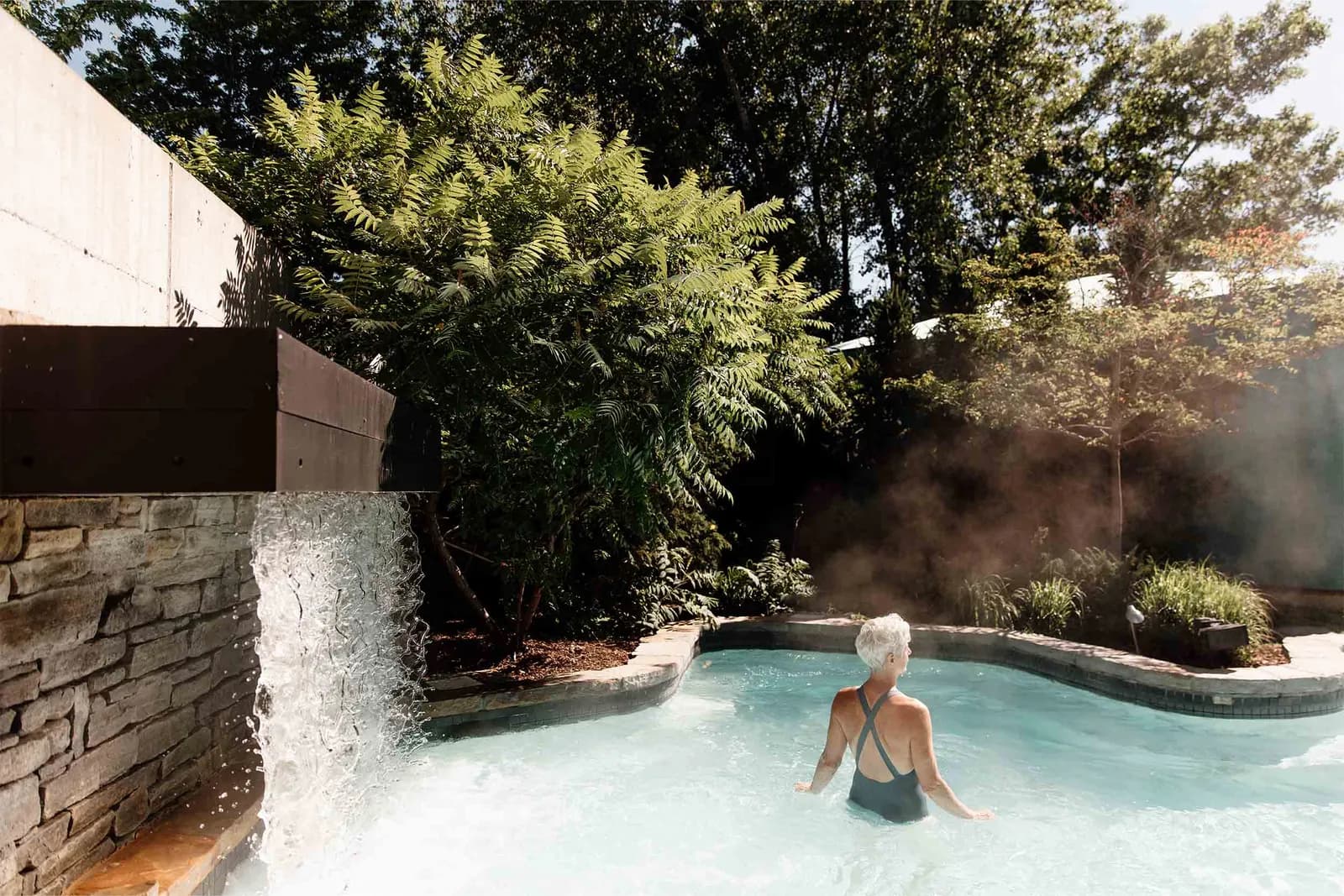 Thermal waterfall pouring into an outdoor pool at Strøm Spa Nordique Île-des-Sœurs