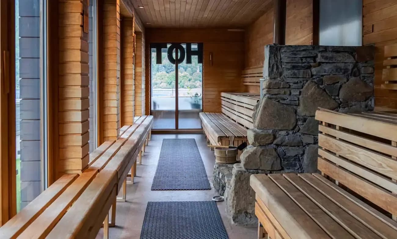 Wood-fired panoramic sauna at Taymouth Marina HotBox Spa with aspen-lined benches and stone hearth overlooking Loch Tay