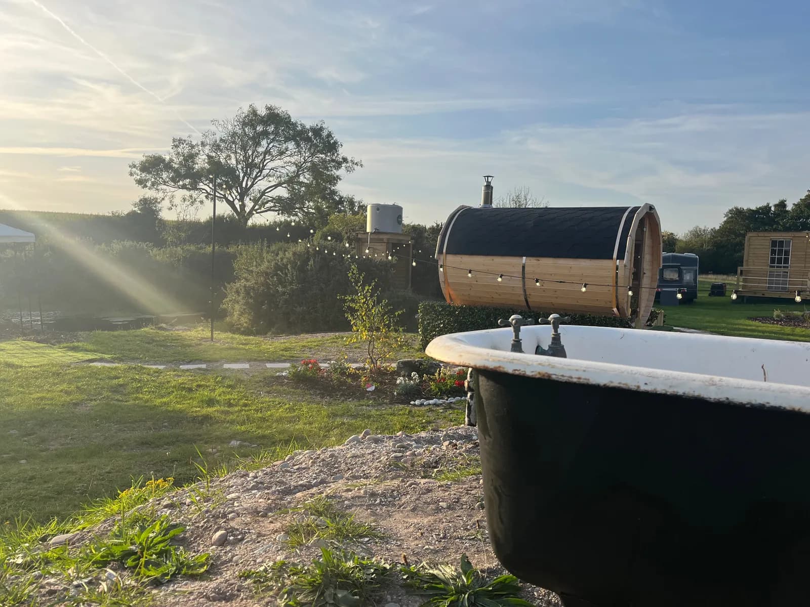 Daytime view of Hidden Sauna Bridgefield showing the barrel sauna and outdoor bathtub with countryside views