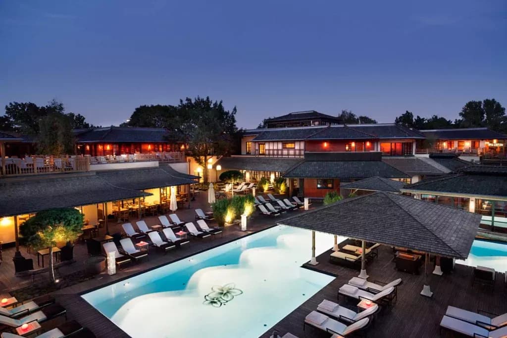 Outdoor pool and Balinese-style pavilions at Vabali Spa Berlin at dusk