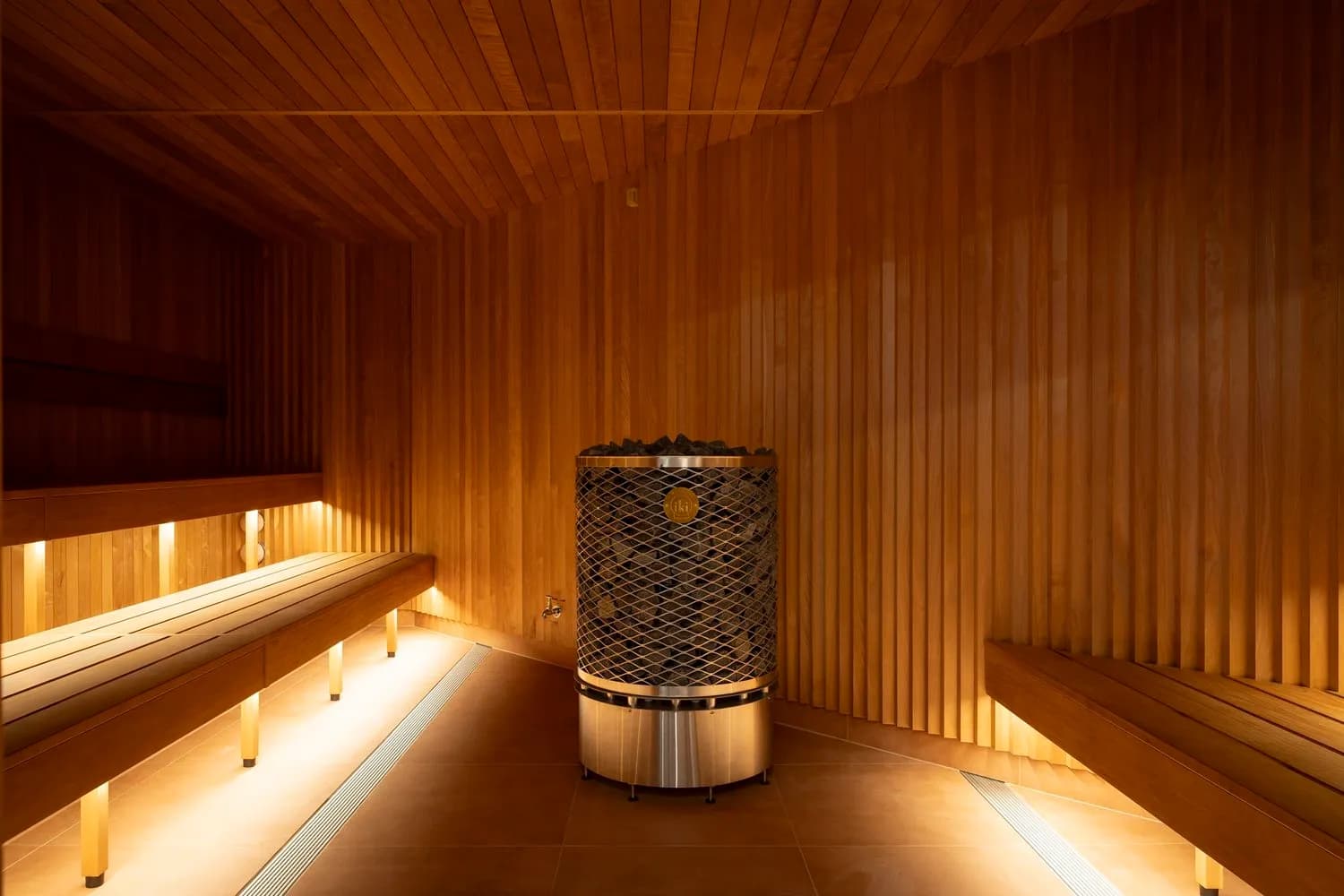 Traditional dry-heat sauna room at Wellbeing Elements with wooden benches and ambient lighting