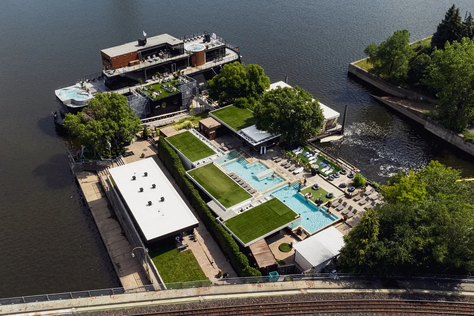 Aerial view of Bota Bota's spa boat, pools, and gardens on the St. Lawrence River in Montreal's Old Port