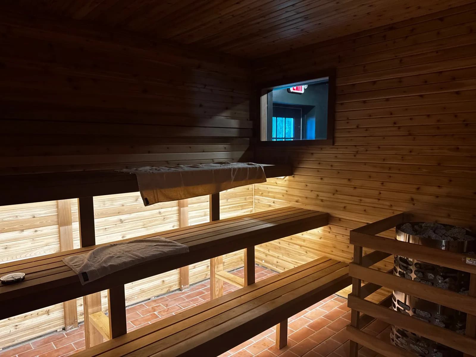 Cedar benches and stone heater inside the Finnish sauna at Gainesville Sauna House