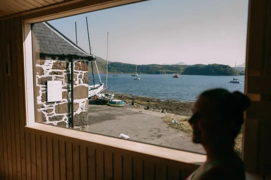 Wood-fired sauna interior with Portree Harbour view