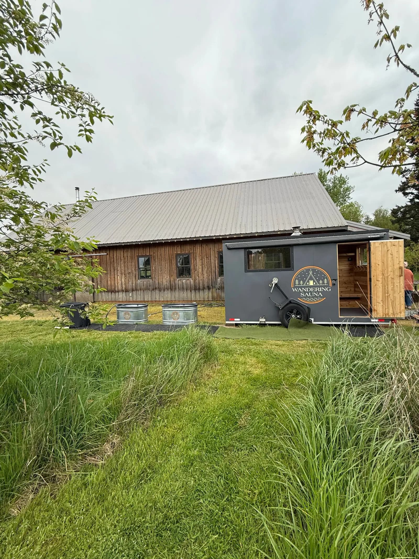 Wandering Saunas mobile wood-fired sauna trailer with cold plunge tubs alongside